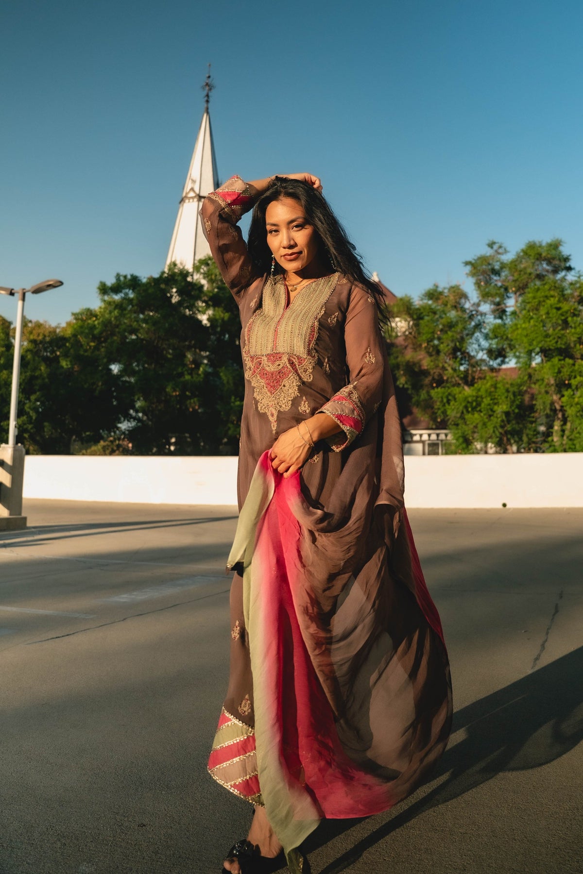 Brown embroidered ensemble with a pink-edged drape